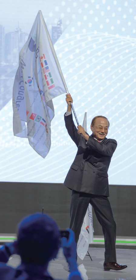 박한길 회장이 2026 세계대회 한국 개최 발표 후 ​​​​​​​​​​​​​​한국 대표단 깃발을 흔들고 있다.